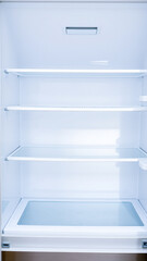 empty white refrigerator with glass shelves