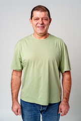 Obraz premium Smiling middle-aged man with short hair in a light green shirt against a simple backdrop
