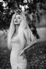 Portrait of a young beautiful blonde girl in nature. Black and white photo.