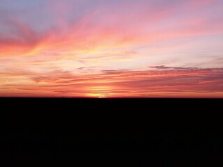 Fototapeta premium Vibrant gradient of oranges, pinks, and purples in a mesmerizing sunset over the horizon, peaceful, vibrant