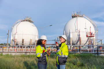 Two female engineers discussing operations at an industrial gas storage facility, emphasizing...