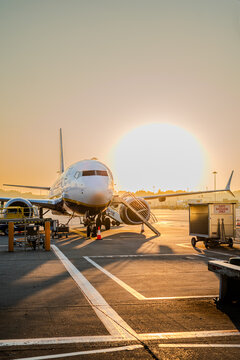 Ryanair plane parked on stand with a sunset background at Stansted Airport in England