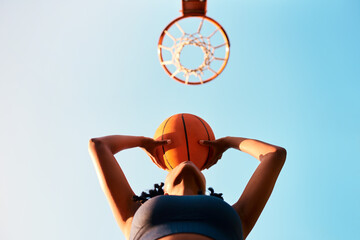 Woman, sports and ball as basketball player or athlete for challenge, goal or training with blue...