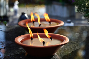 Ogień na symbolicznym zniczu na grobie ku pamięci. © FotoDax