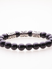 A charming double bracelet in shades of pink, made from natural stone and set against a gray background. The heart charm with cubic zirconia stands out in this close-up top view