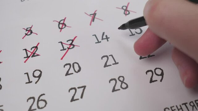 A closeup of a hand marking a date on a calendar, highlighting effective organization and time management