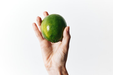 Person holding lime on white background with copy space, isolated from rest of image
