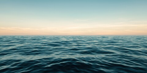 Fototapeta premium Calm ocean waves under a clear sky at dusk.