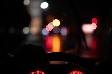 雨の夜に自動車を運転する男性の手元