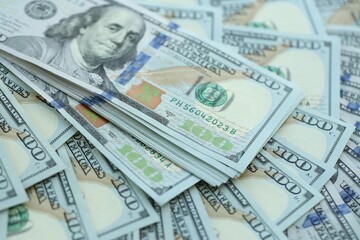 Many hundred dollar bills new banknotes in big pile under the natural light