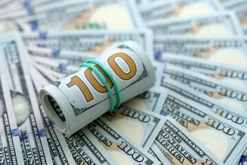 Roll of hundred dollar bills USD banknotes lies on big amount of united states money