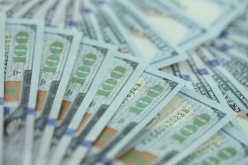 Many hundred dollar bills new banknotes in big pile under the natural light