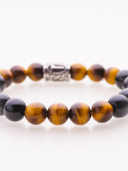 A charming double bracelet in shades of pink, made from natural stone and set against a gray background. The heart charm with cubic zirconia stands out in this close-up top view