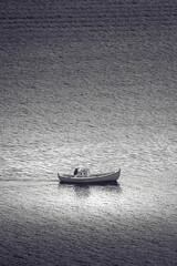 Ein Fischer fährt mit seinem Boot in einem Fjord auf den Färöer Inseln