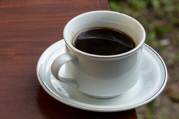 Black Coffee in Ceramic Cup on Wooden Table