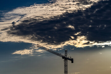 The tower crane on sunset sky. Industrial construction equipment. Tower Cranes. Construction site....