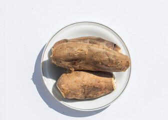 Sweet potato set on ceramic plate on white background