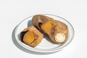 Sweet potato set on ceramic plate on white background