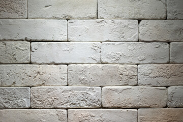 White brick wall with roughly surface. Building structure and interior decoration, background texture. Close-up.