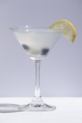 Cocktail garnished with berry and a slice of lemon