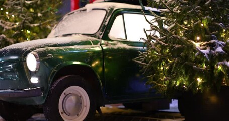 Christmas retro car with gifts on the roof on a winter snowy evening