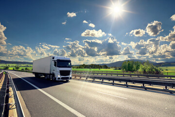 Large Transportation Truck on a highway road through the countryside at sunset