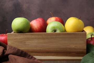 Fresh ripe apples in wooden crate on table