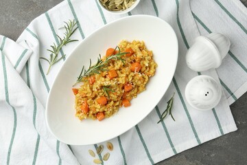 Delicious pumpkin risotto with rosemary on grey table, flat lay