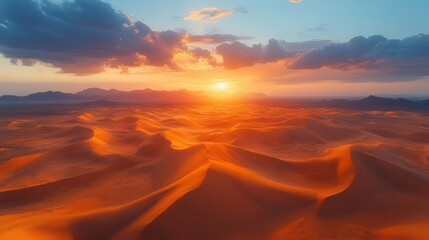 Naklejka premium desert landscape showcasing dramatic clouds in a moody sky at sunset the sun casting a warm glow over golden sand dunes creating a breathtaking and tranquil scene of natures beauty