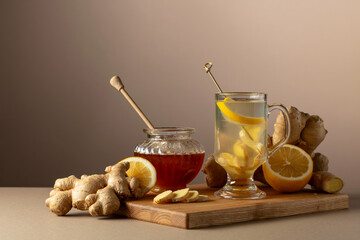 Ginger tea with lemon and honey on a beige background.
