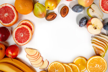 frame with fresh sliced fruits on a white background. frame with oranges, grapefruit, pears and plums on a white background