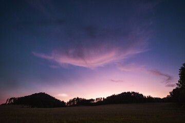 Evening meadow with interesting clouds on purple sky, Hrensko, Czech republic