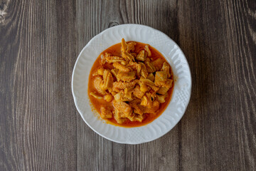A dish from Turkish cuisine. Lamb tripe with chickpeas served on a white plate.