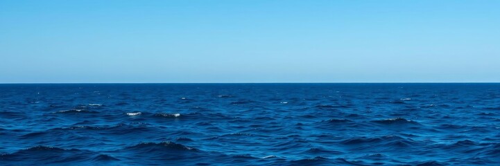 Obraz premium Vast expanse of deep blue ocean under a clear sky, with gentle waves and distant horizon, waves, scenic