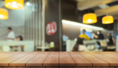 Obraz premium Empty wooden table top with lights bokeh on blur restaurant background.