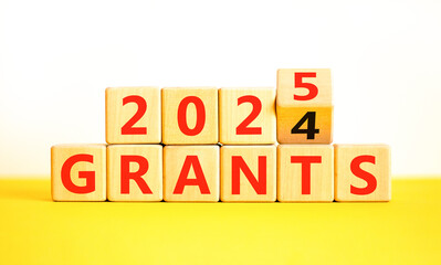 Planning 2025 grants new year symbol. Concept words 2024 Grants to 2025 Grants on beautiful wooden blocks. Beautiful yellow table white background. Business 2025 grants new year concept. Copy space.