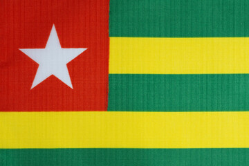 Background, national flag of Togo on textured fabric.