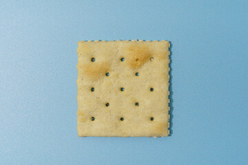 Single Square Saltine Cracker On Blue Background