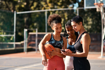 Basketball, friends and girls with phone for sports schedule, social media or show message on chat app. Mobile, ball or group of women outdoor on break after training, fitness or online game on court