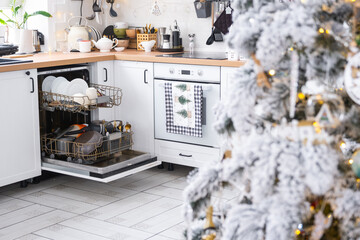 A lot of dirty dishes in the dishwasher in the festive kitchen. Helping the hostess, economy and...