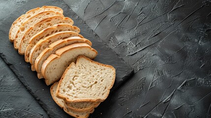 Sliced bread on dark stone surface seen from above