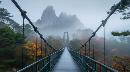 Obraz premium Scenic Suspension Bridge Over Misty Mountains