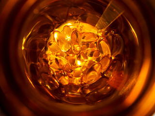 Omega 3 capsules in a jar. Top view of capsules in sunlight. Close-up.