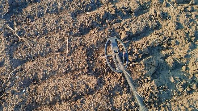 A professional sapper searches for a minefield using a metal detector.