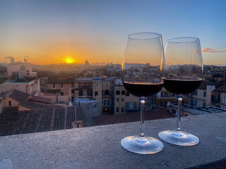 Glasses of wine at sunset with rooftop view over rome italy