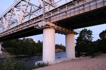 Fototapeta premium An Industrial Bridge Spanning Over a River During the Beautiful Time of Dusk and Evening