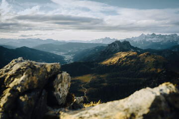 Fototapeta premium A stunning mountain range view with trees and rocks in the foreground