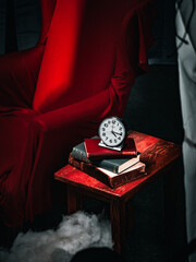 A table with a clock and books on it