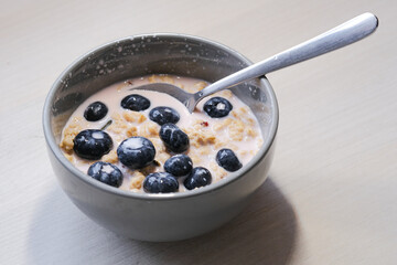 Bright and appetizing breakfast: fresh yogurt with juicy blueberries, crunchy flakes, seeds, and natural grains.