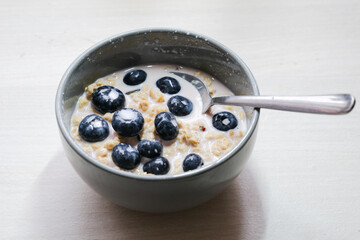 Bright and appetizing breakfast: fresh yogurt with juicy blueberries, crunchy flakes, seeds, and natural grains.